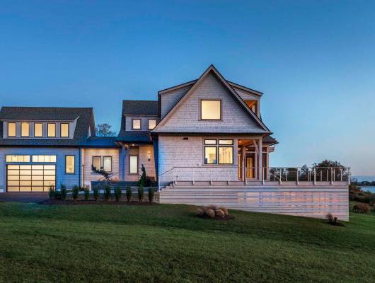 side view of custom home on the water at dusk